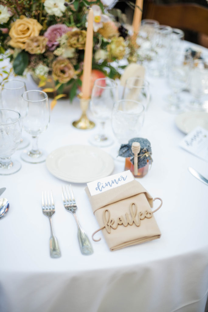 A chic rustic wedding reception at Calamigos Ranch, laser cut wood guest placards
