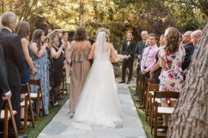 A chic rustic wedding ceremony at Calamigos Ranch, bride walking down the aisle with maid of honor