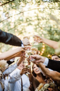 A chic rustic wedding reception at Calamigos Ranch, cocktail hour guest champagne toast
