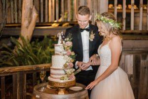 A chic rustic wedding at Calamigos Ranch, bride and groom cake cutting