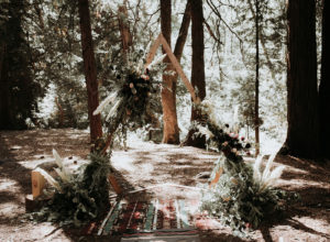 Summer camp themed wedding in Big Bear at Camp Wasegan, forest wedding ceremony in the woods with mismatched oriental rugs and v shaped ceremony arch