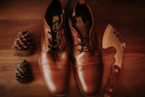 Summer camp themed wedding in Big Bear at Camp Wasegan, groom detail shot, cognac brown leather shoes and axe