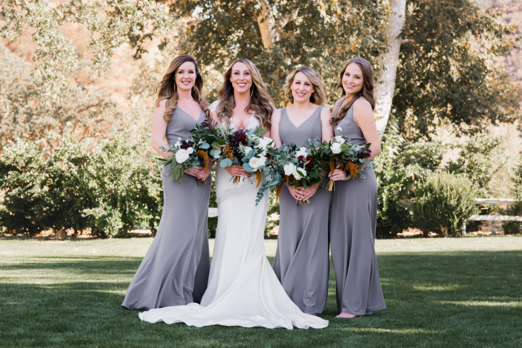A simple and modern wedding at Triunfo Creek Vineyards, bride with bridesmaids wearing grey dresses and bouquets