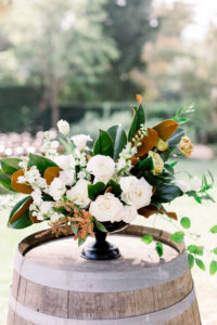 A Romantic Fall Wedding ceremony at Maravilla Gardens, centerpiece with magnolia leaves and white flowers