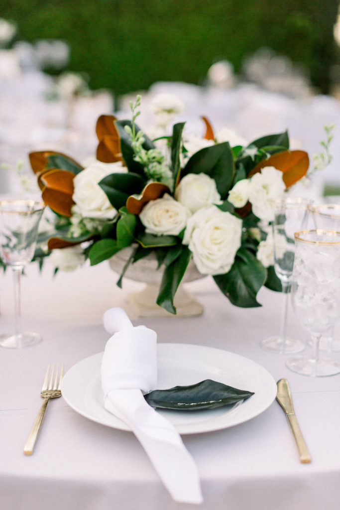 A Romantic Fall Wedding reception at Maravilla Gardens, centerpiece with magnolia leaves and white flowers