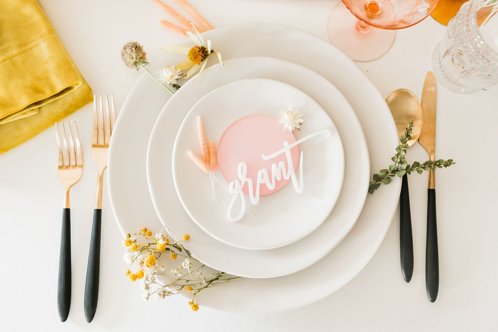 Spring Fever inspired styled shoot at La Piñata + Feathered Arrow Events using orange, pink and yellow in your wedding, wildflower centerpiece, neutral plates with bright pink accents