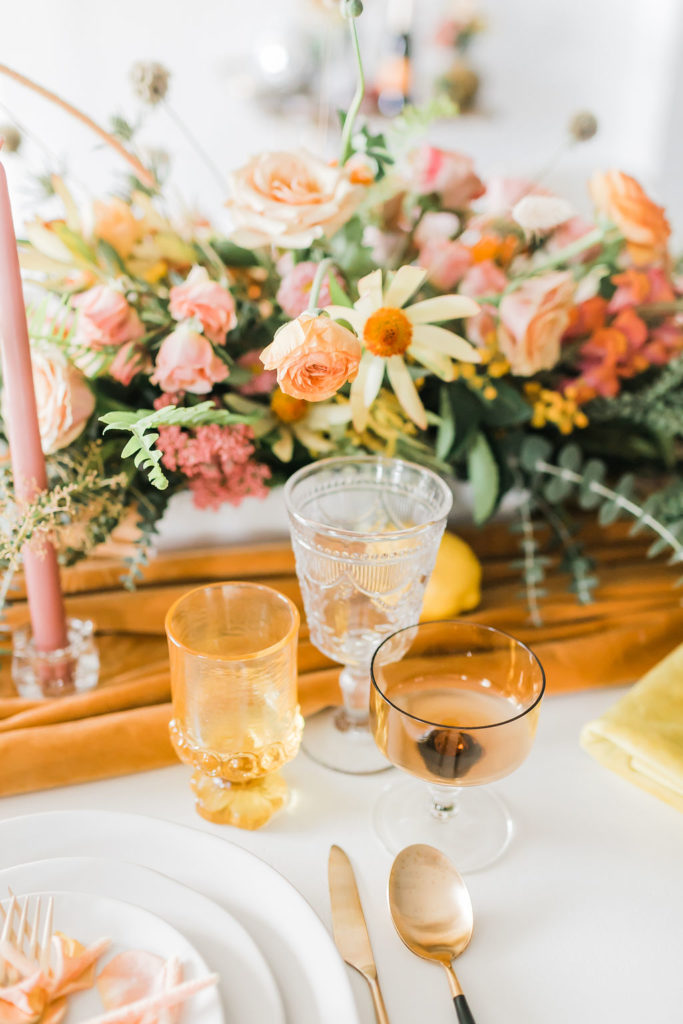 Spring Fever inspired styled shoot at La Piñata + Feathered Arrow Events using orange, pink and yellow in your wedding, wildflower centerpiece and orange dishware and table runner