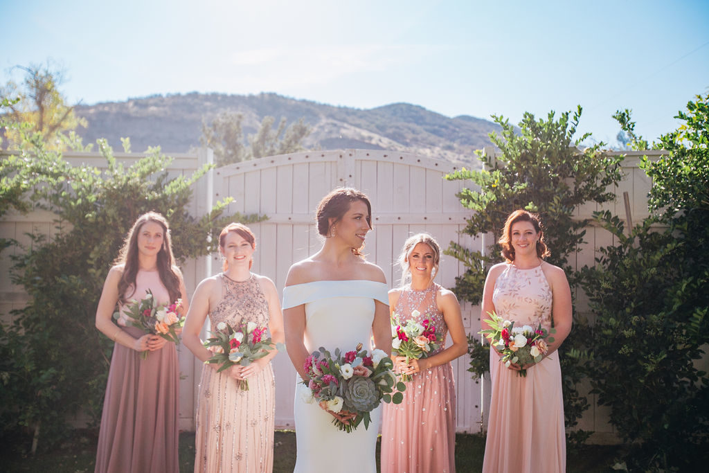 Fall Wedding at Triunfo Creek Vineyards, bride with off shoulder wedding dress and bridesmaids in blush and purple dresses