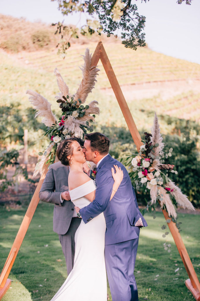 Fall Wedding ceremony at Triunfo Creek Vineyards, bride and groom first kiss