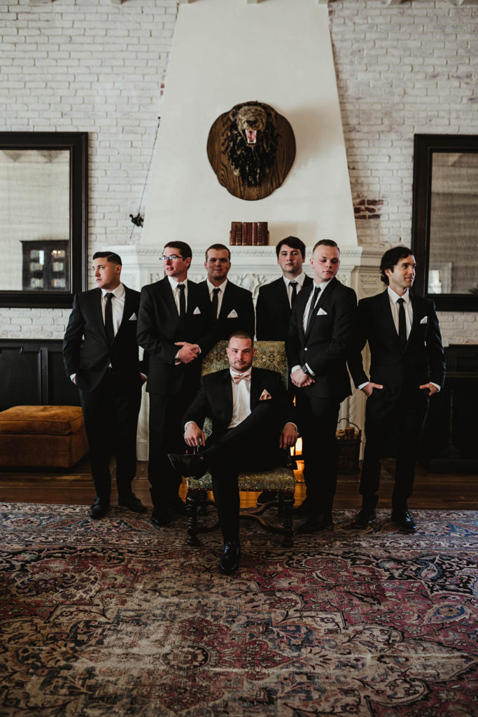 A romantic wedding at Ebell Long Beach, groomsmen portrait shot wearing black suits and pink bowtie