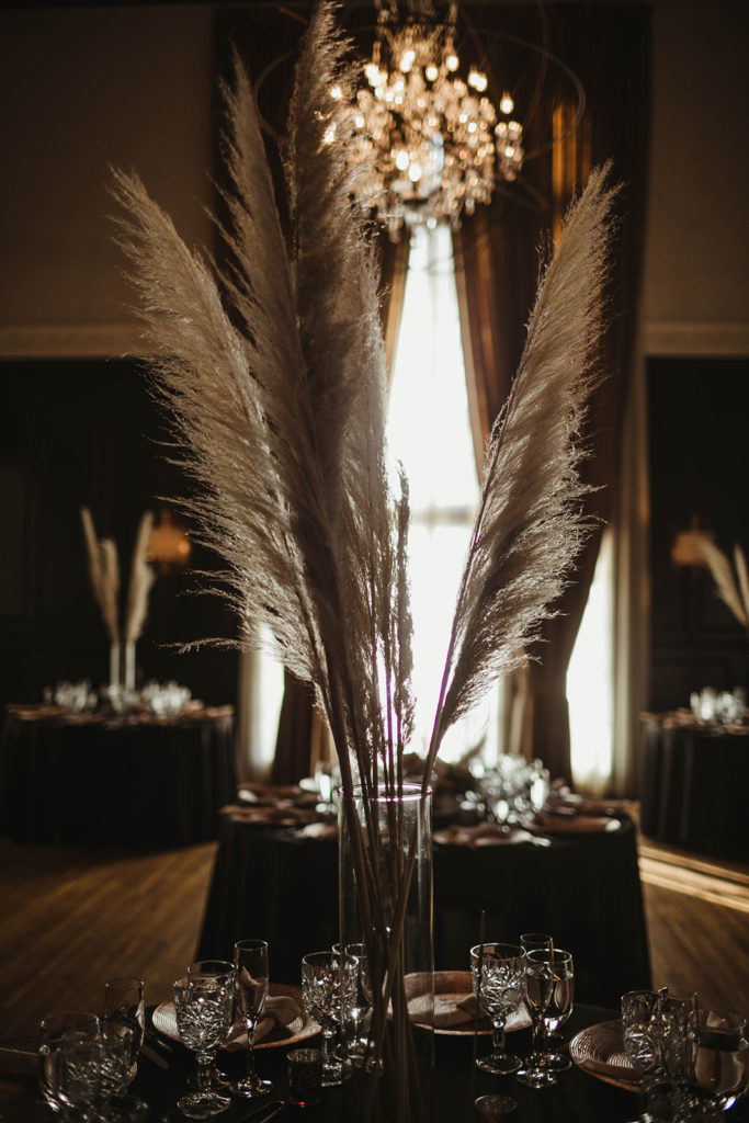 A romantic wedding reception at Ebell Long Beach, table centerpiece with pampas grass