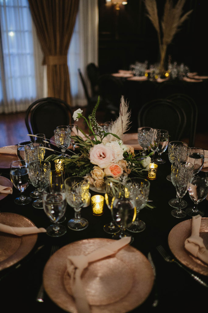 A romantic wedding reception at Ebell Long Beach, floral centerpiece with blush and gold flowers
