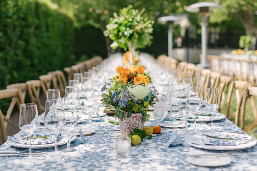 An Al Fresco Wedding reception at the Valley Hunt club, Italian inspired wedding reception, family style table with blue floral patterned tablecloth and fresh citrus 