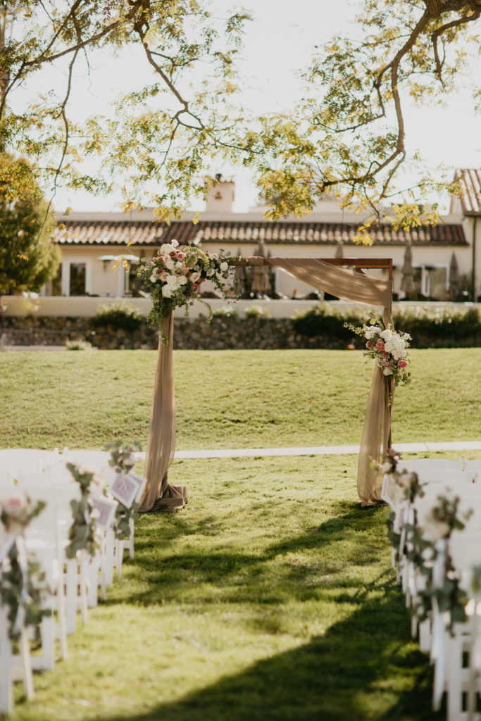 A music festival themed wedding ceremony at The Inn at Rancho Santa Fe, arch with silk drapery