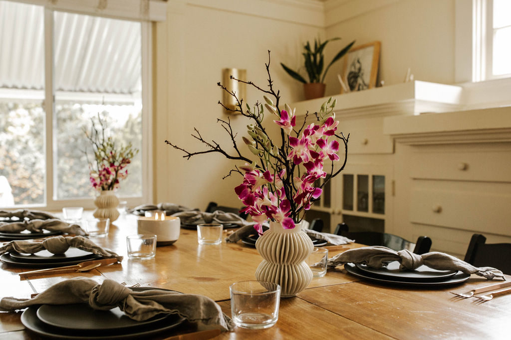 Create Dinners tables cape with black matte plates and bright orchid centerpiece