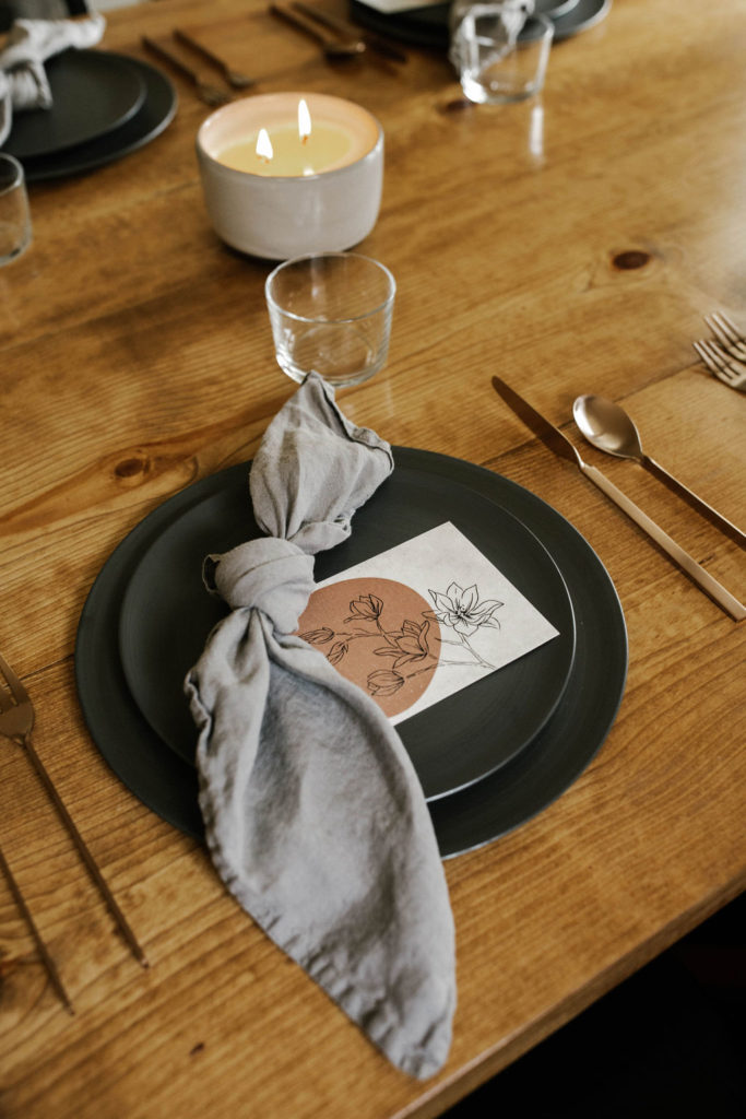 Create Dinners tables cape with black matte plates and orchid centerpieces