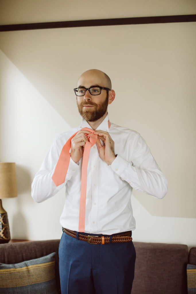 A unique and colorful wedding at the Grass Room in downtown Los Angeles, groom wearing pink tie getting ready