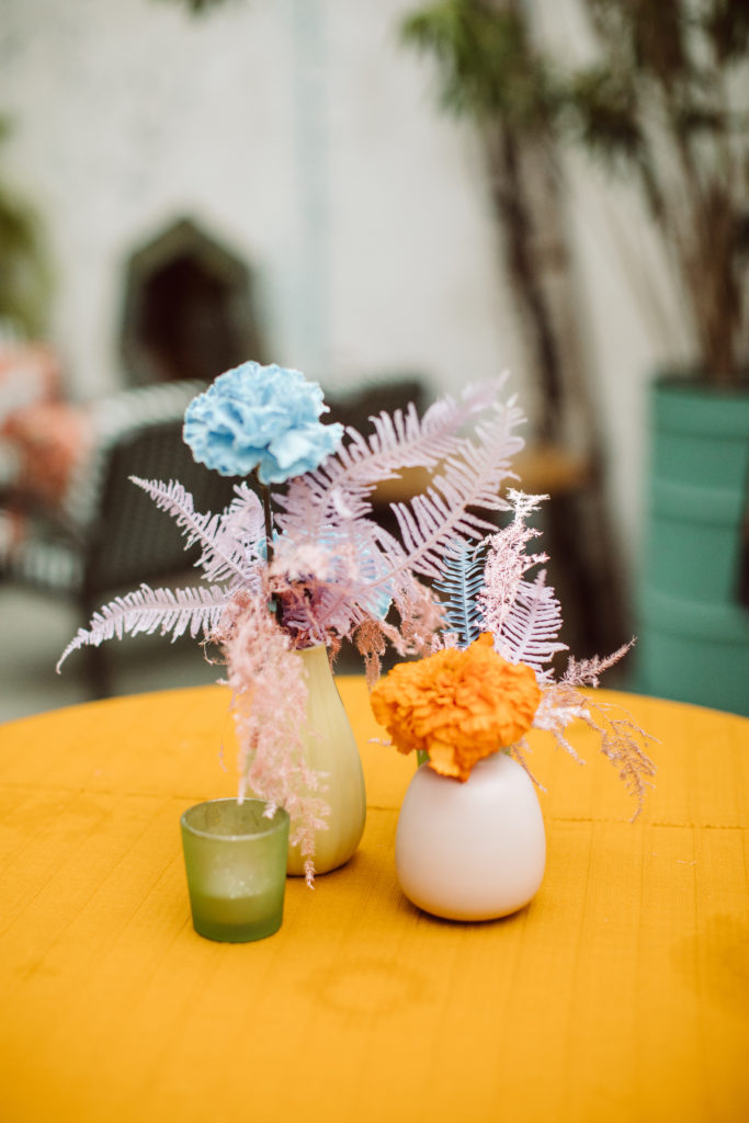 A unique and colorful wedding cocktail hour at the Grass Room in downtown Los Angeles, eclectic flower centerpiece