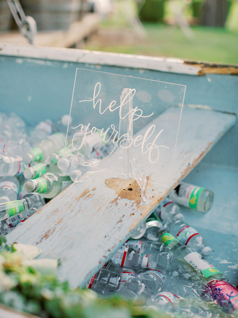 A colorful and vibrant wedding at Triunfo Creek Vineyards, cocktail hour sign