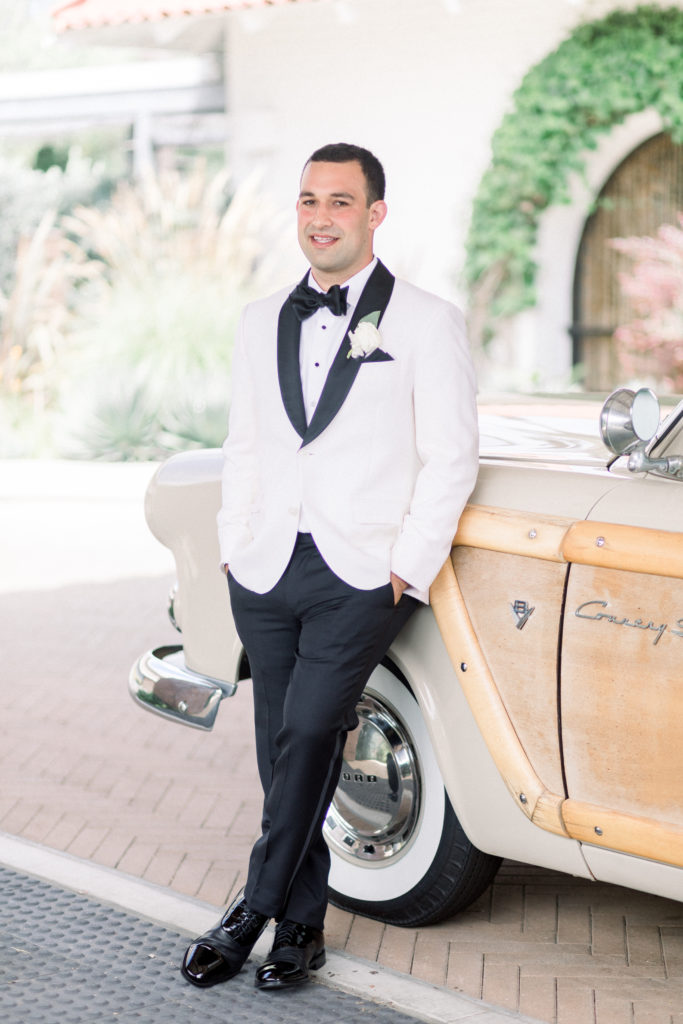 A classic greenhouse wedding at Dos Pueblos Orchid Farm, groom in white and black tux, groom  portrait shot