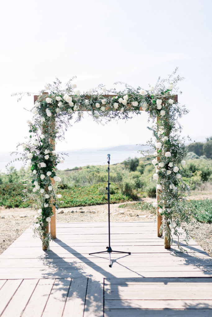A classic greenhouse wedding ceremony at Dos Pueblos Orchid Farm, green and white ceremonial arch