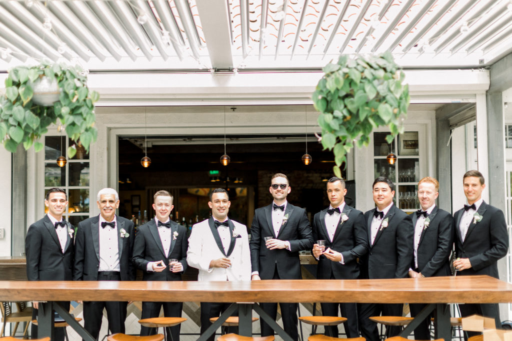 A classic greenhouse wedding at Dos Pueblos Orchid Farm, groom in white tux with groomsmen in black suits
