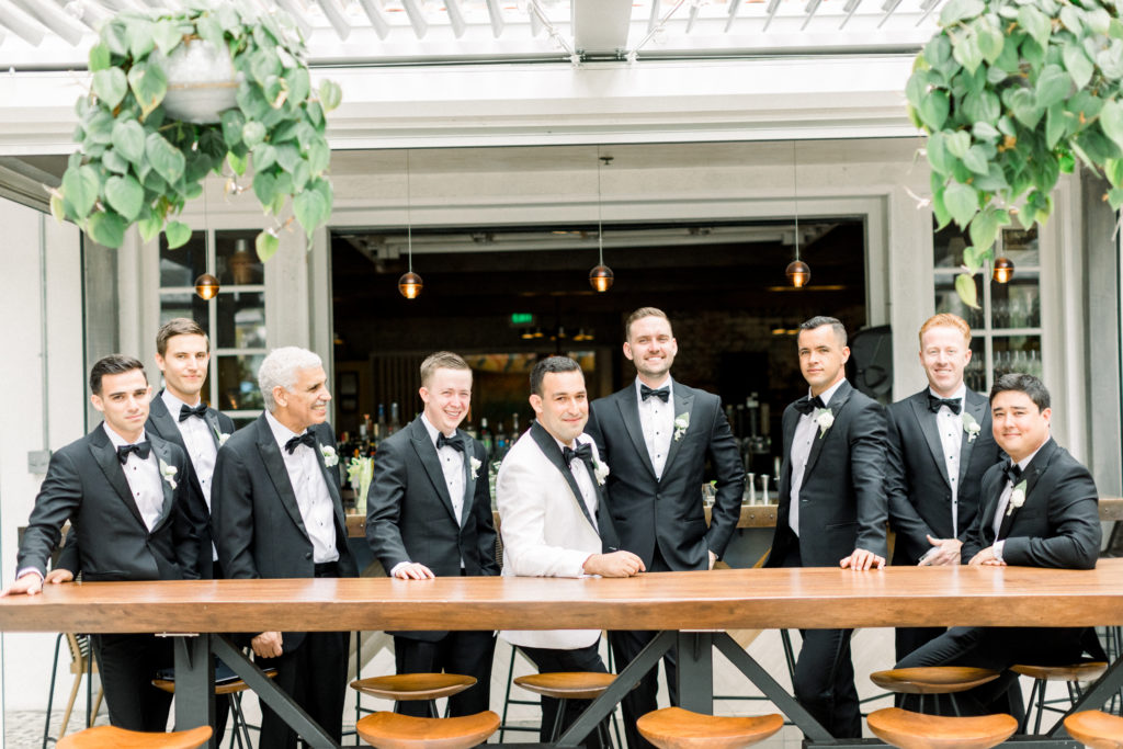 A classic greenhouse wedding at Dos Pueblos Orchid Farm, groom in white tux and groomsmen in black suits