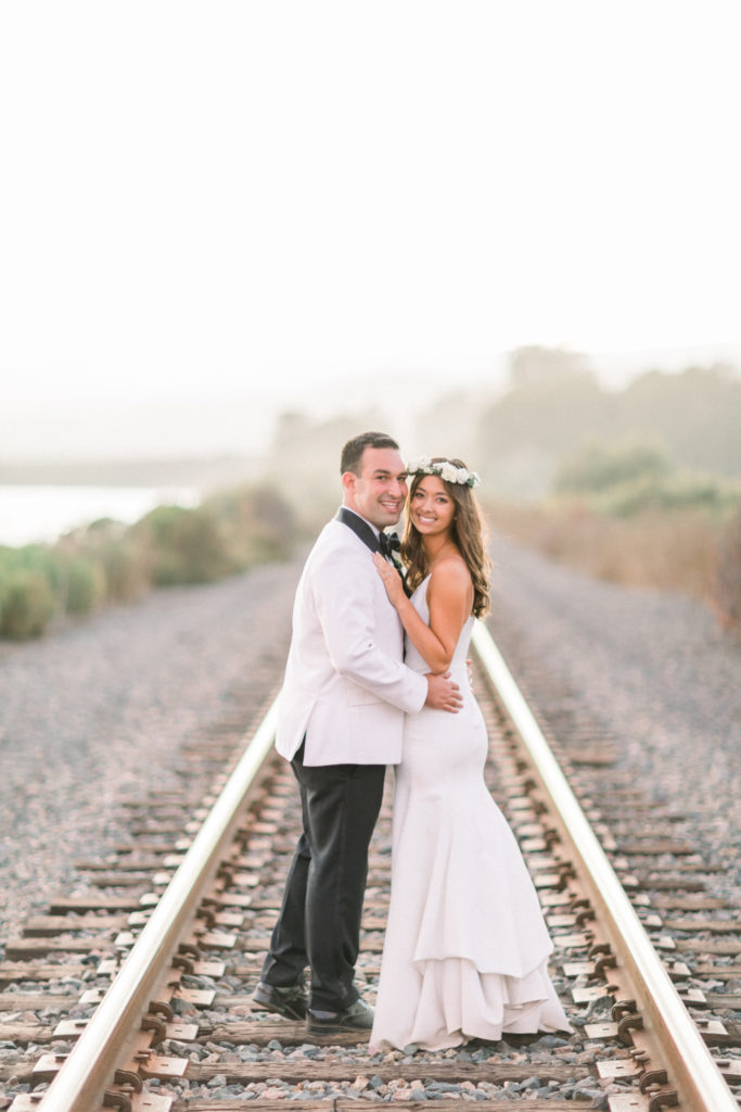 A classic greenhouse wedding reception at Dos Pueblos Orchid Farm, bride and groom portrait shot at railroad