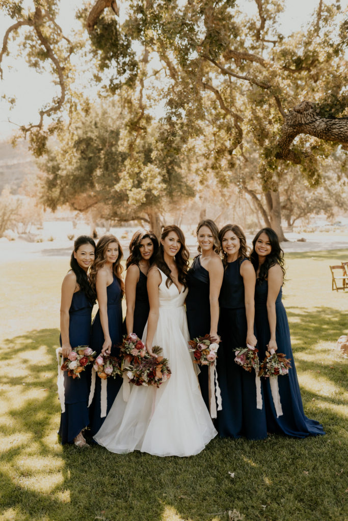 A whimsical wedding at Triunfo Creek Vineyards, bride and bridesmaids in navy blue dresses