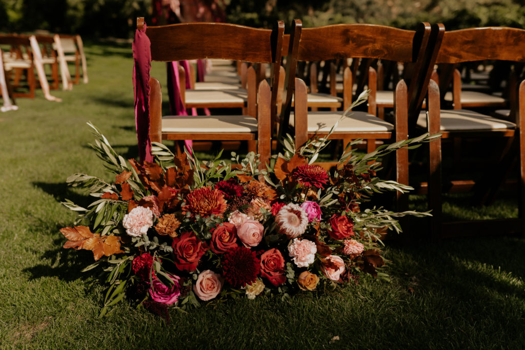 A whimsical wedding at Triunfo Creek Vineyards, wedding ceremony pink and orange aisle flowers