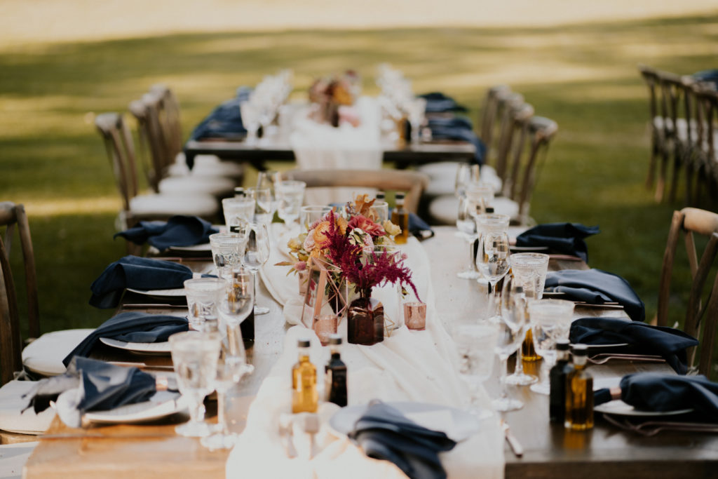 A whimsical wedding reception at Triunfo Creek Vineyards, farm table with navy blue napkins