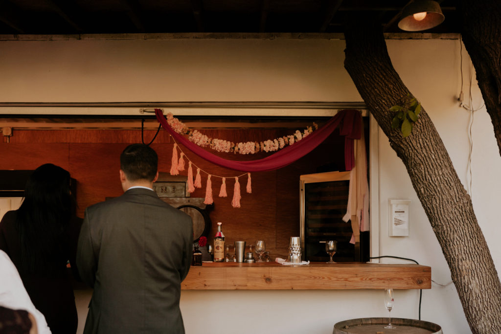A whimsical wedding reception at Triunfo Creek Vineyards, tassel bar decor