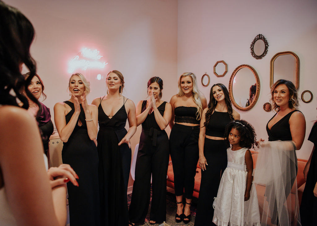 Beautiful wedding at The Unique Space in downtown LA, bridesmaids in black dresses reaction to bride getting ready