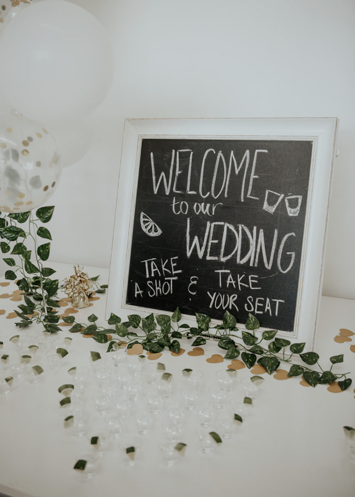 Beautiful wedding at The Unique Space in downtown LA, chalkboard wedding welcome sign with tequila shots at welcome table