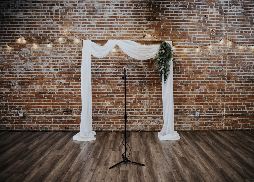 Beautiful wedding at The Unique Space in downtown LA, ceremony arch with white draping 