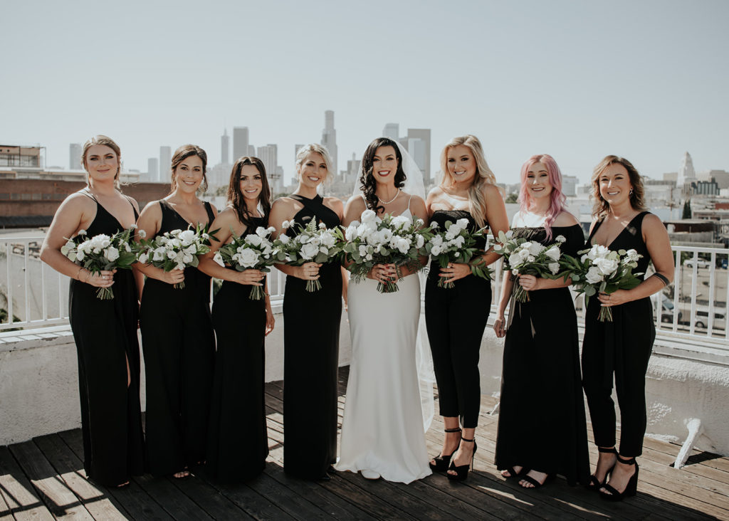 Beautiful wedding at The Unique Space in downtown LA, bride with bridesmaids in black dresses, downtown city skyline
