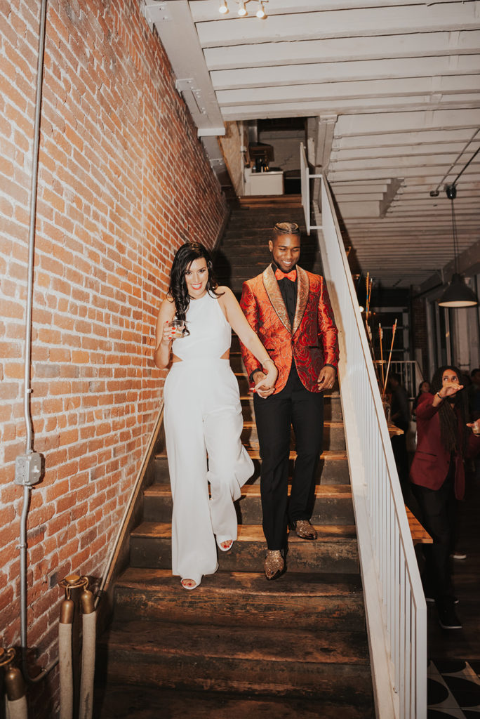 Beautiful wedding at The Unique Space in downtown LA, bride in bridal jumpsuit and groom in red suit jacket