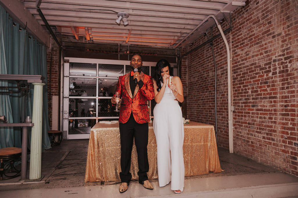 Beautiful wedding at The Unique Space in downtown LA, bride in white bridal jumpsuit and groom in red suit jacket