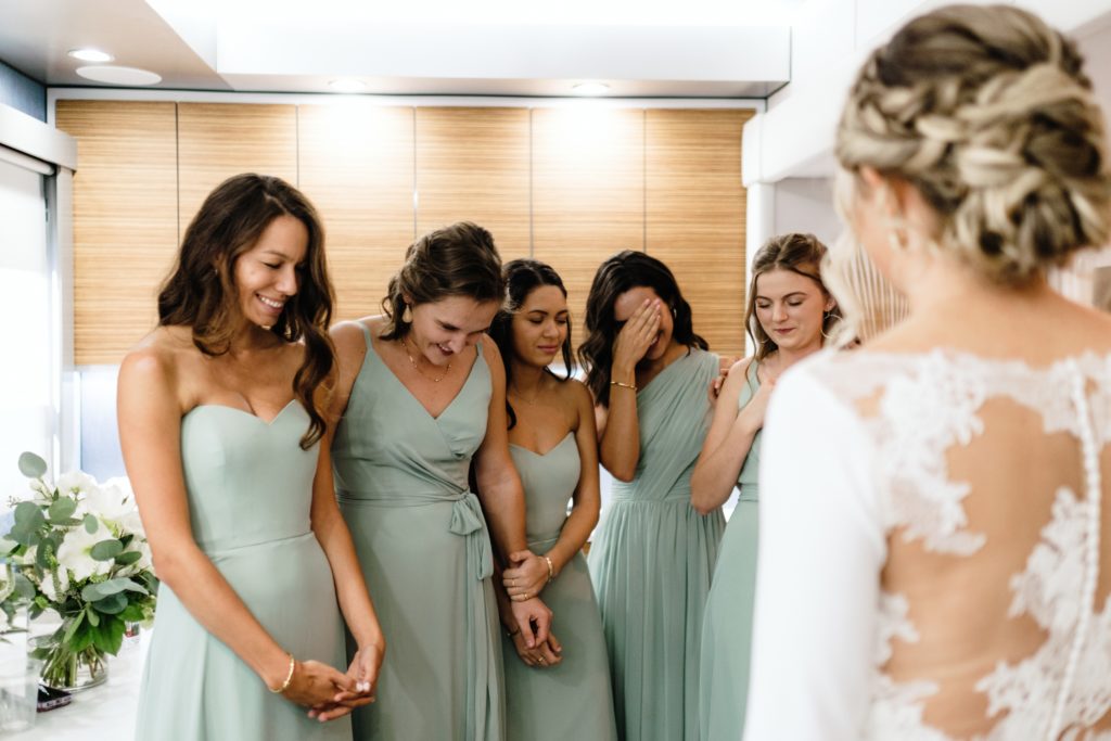 A Classic Vineyard Wedding at Triunfo Creek Vineyards, bridesmaids in sage green dresses see bride for first time