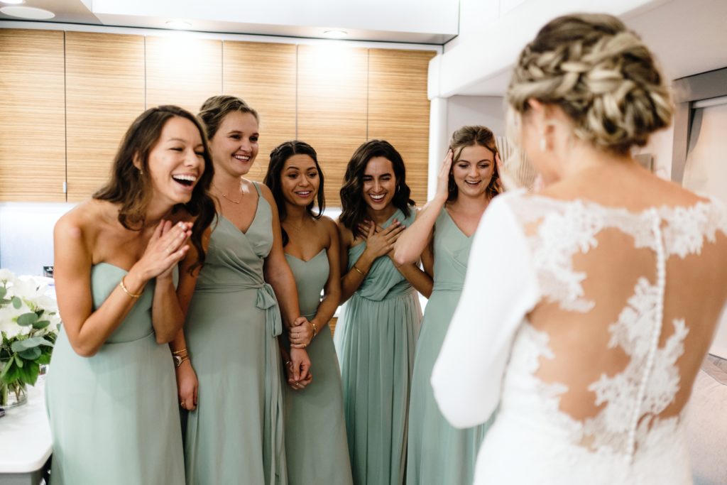 A Classic Vineyard Wedding at Triunfo Creek Vineyards, bridesmaids in sage green dresses see bride for first time
