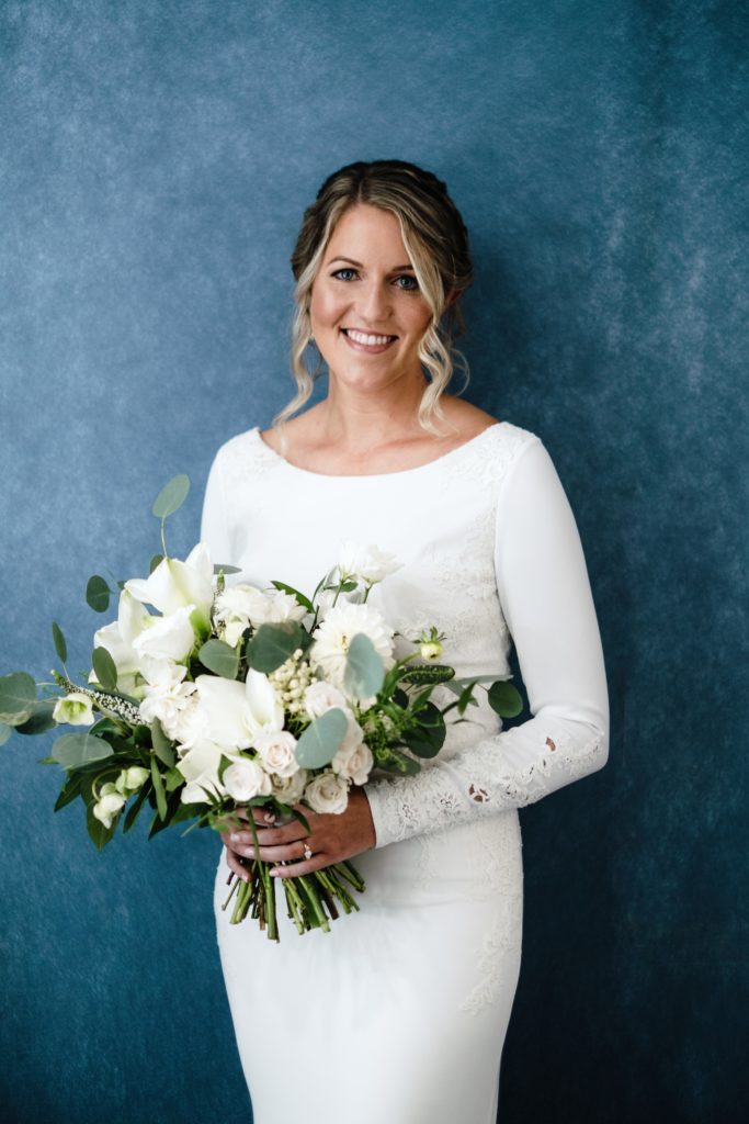 A Classic Vineyard Wedding at Triunfo Creek Vineyards, bride in long sleeve wedding dress with green and white bridal bouquet