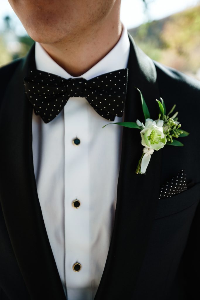 A Classic Vineyard Wedding at Triunfo Creek Vineyards, groom and groomsmen in black suits, green and white boutonniere 