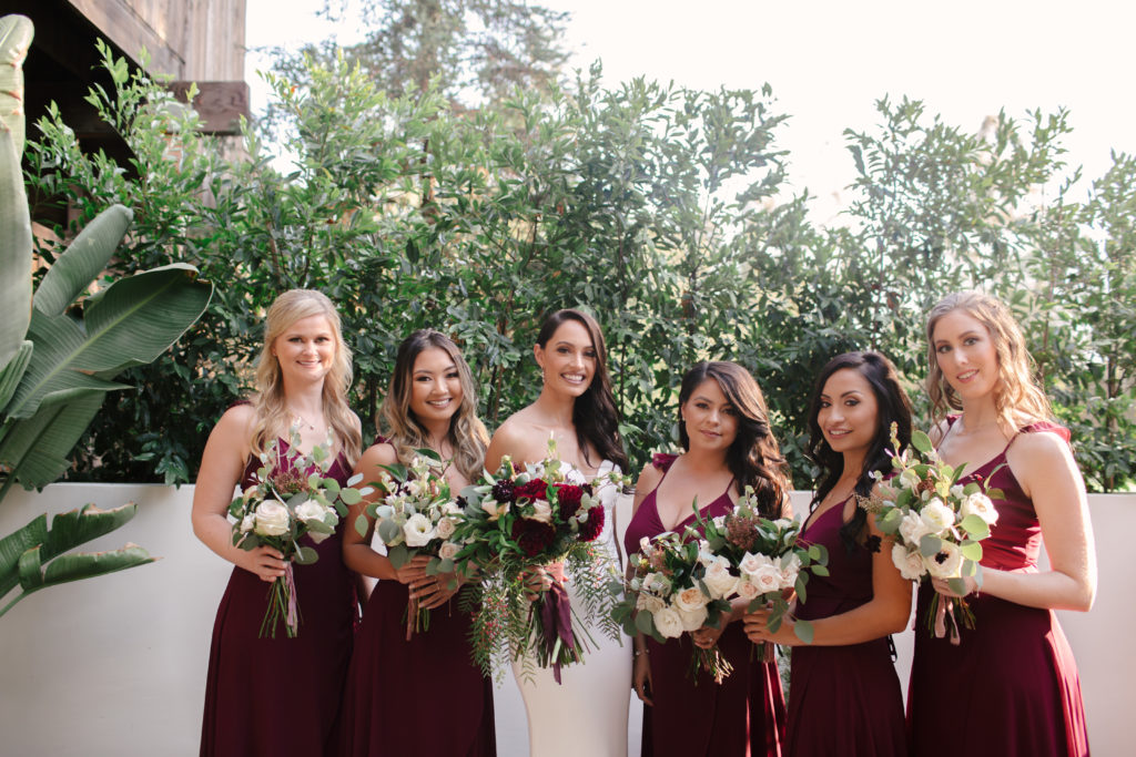 A Fall Wedding at Calamigos Ranch, bride with bridesmaids in deep burgundy bridesmaid dresses