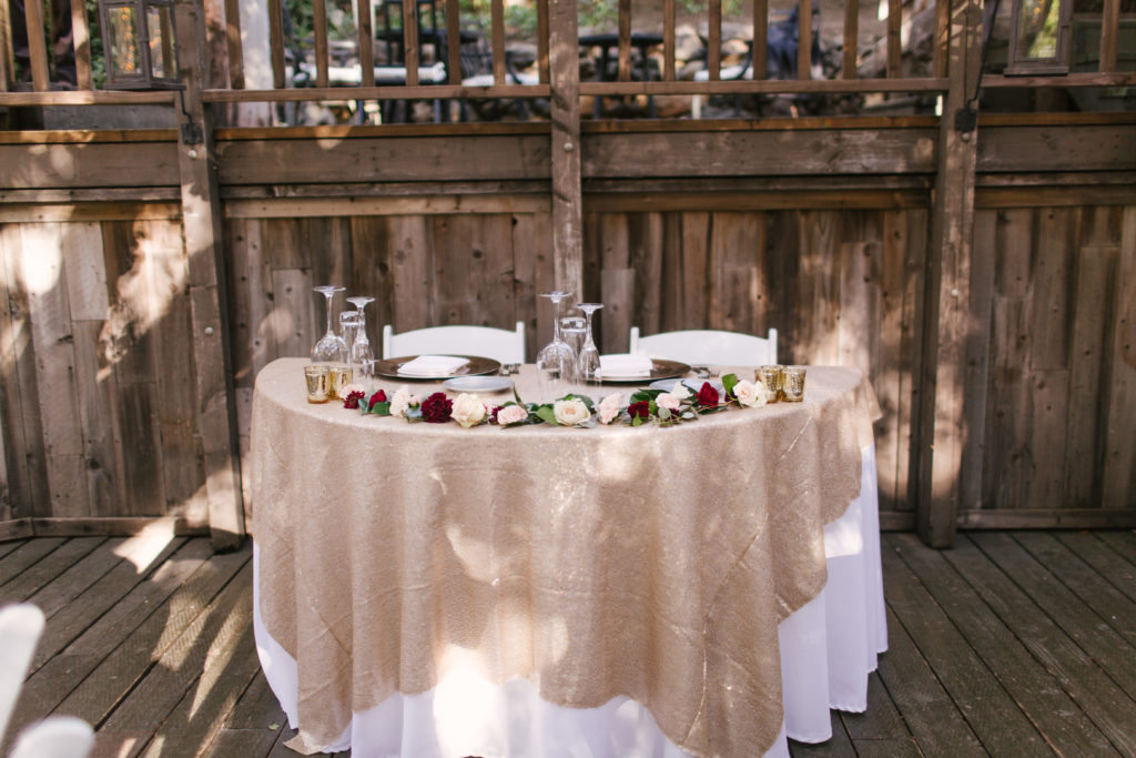A Fall Wedding reception at Calamigos Ranch, sweetheart table with gold table cloth