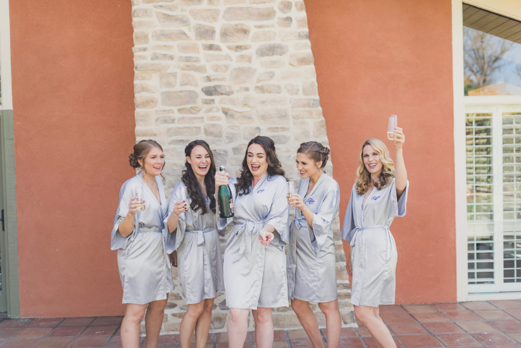 A Springtime Malibu Wedding at Calamigos Ranch, bride and bridesmaids pop champagne