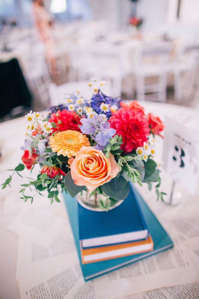 Storybook themed wedding reception at The York Manor with book page table runners and bright colorful floral centerpieces