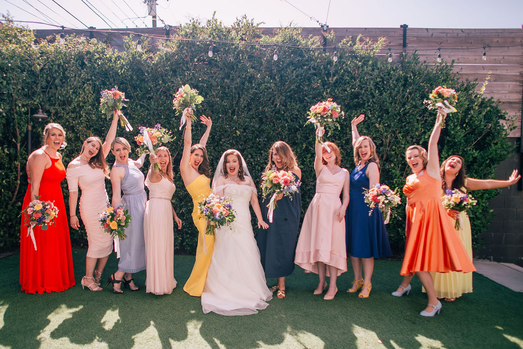 bride with bridesmaids in rainbow colored mix and match bridesmaid dresses