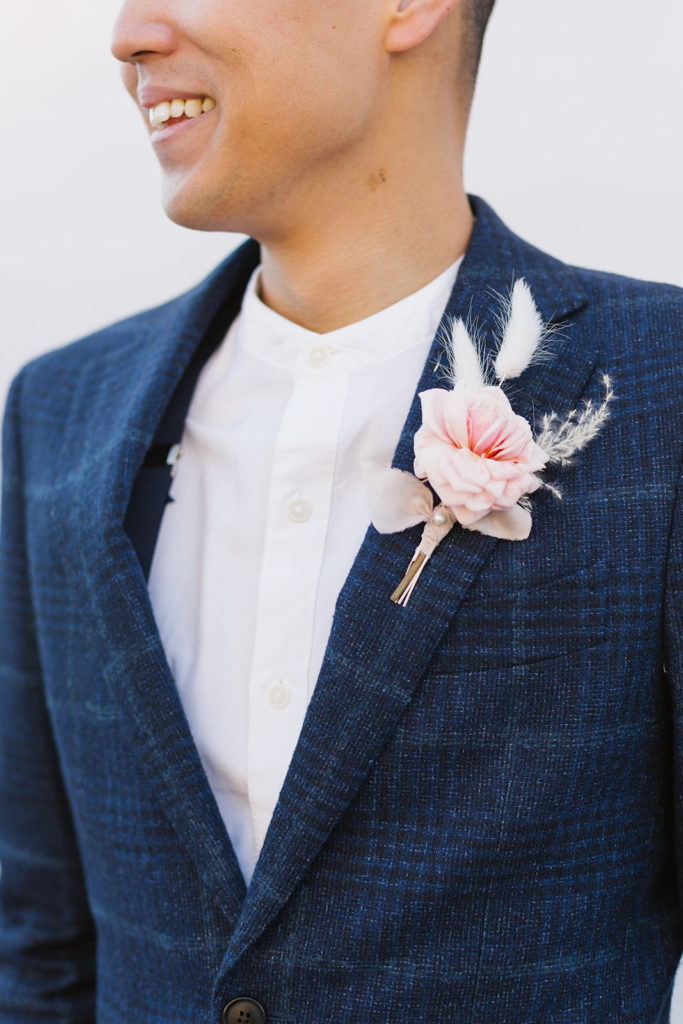 groom in blue suit with pampas grass boutonniere 