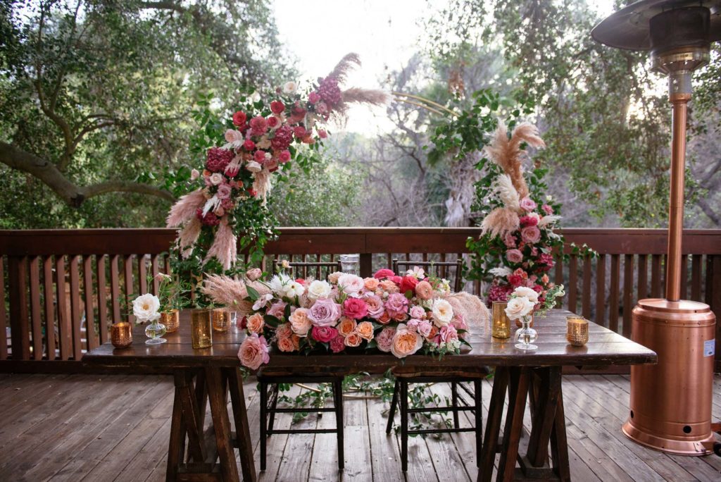 micro wedding reception at the 1909, sweetheart table with gold circular backdrop and pink and white florals