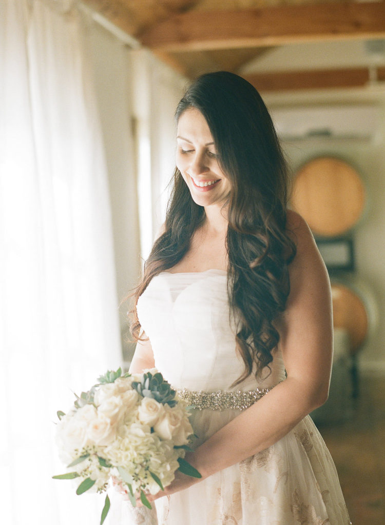 bridal portrait shot in strapless wedding dress with brocade details bridal bouquet with succulents